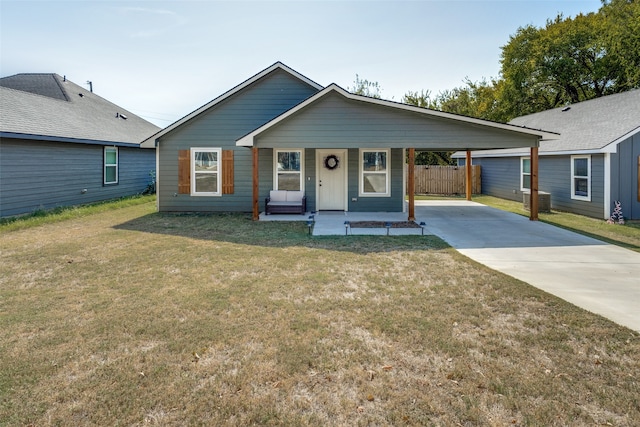 ranch-style home with covered porch, a carport, and a front yard