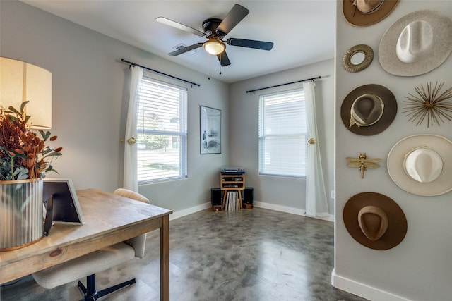 office area featuring concrete floors, a healthy amount of sunlight, and ceiling fan