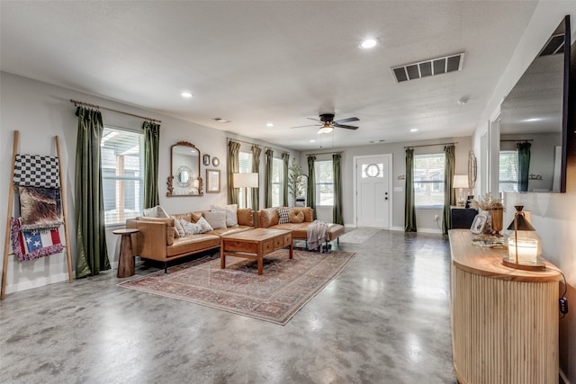 living room featuring a textured ceiling, concrete flooring, and ceiling fan