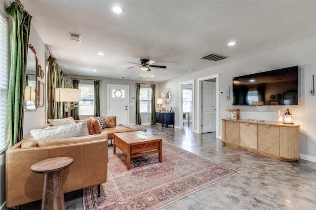 living room featuring ceiling fan and a textured ceiling