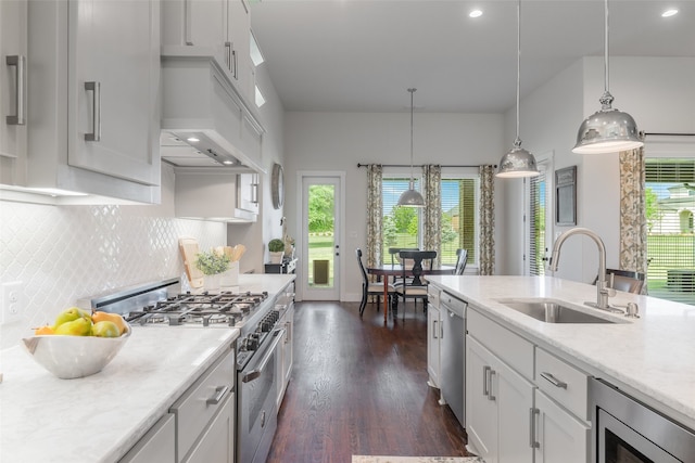 kitchen with appliances with stainless steel finishes, decorative light fixtures, a wealth of natural light, and sink