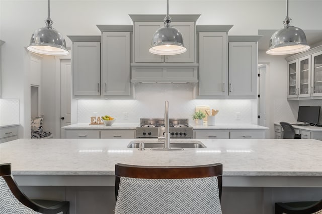 kitchen with gray cabinetry, pendant lighting, and a breakfast bar area