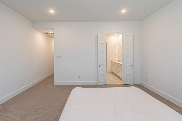 carpeted bedroom featuring ensuite bath