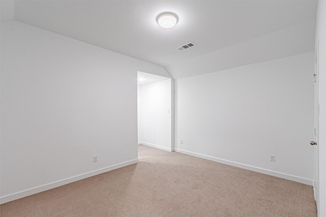 carpeted spare room with lofted ceiling