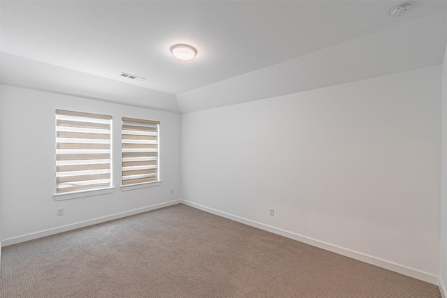 unfurnished room with vaulted ceiling and light colored carpet