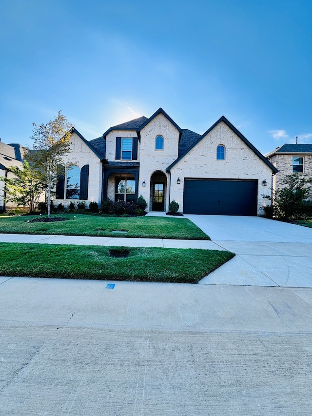 french country home with a front yard and a garage