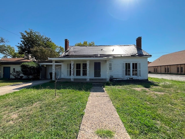 view of front of property featuring a porch, a front yard, and a garage