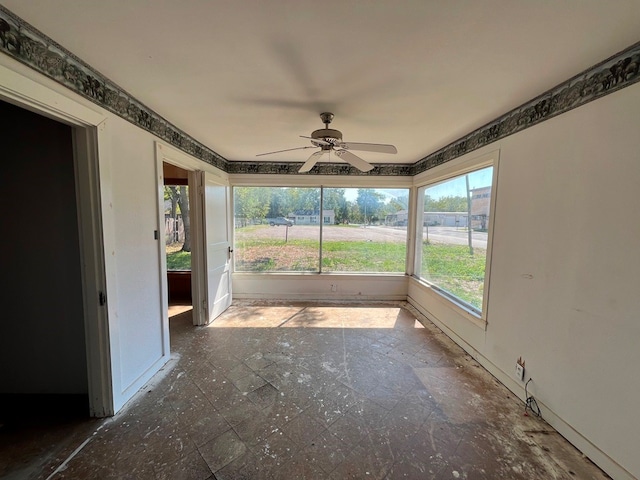 unfurnished sunroom featuring ceiling fan