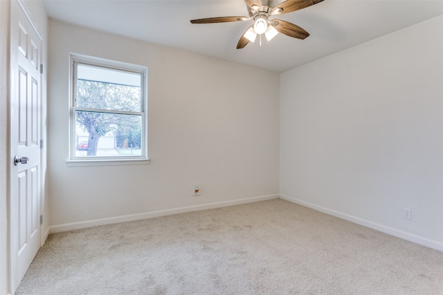 spare room featuring light colored carpet and ceiling fan