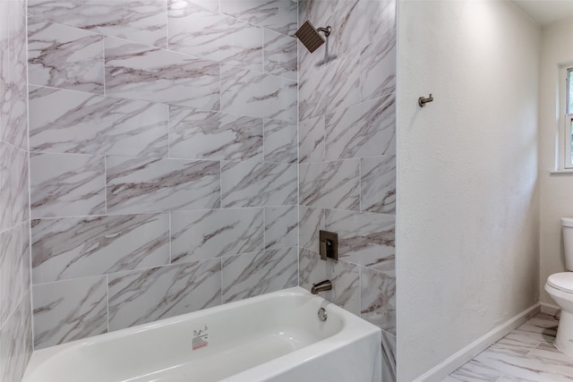 bathroom featuring toilet and tiled shower / bath