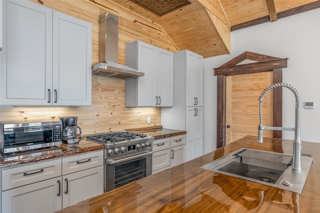 kitchen featuring white cabinets, sink, wall chimney exhaust hood, and stainless steel gas stove