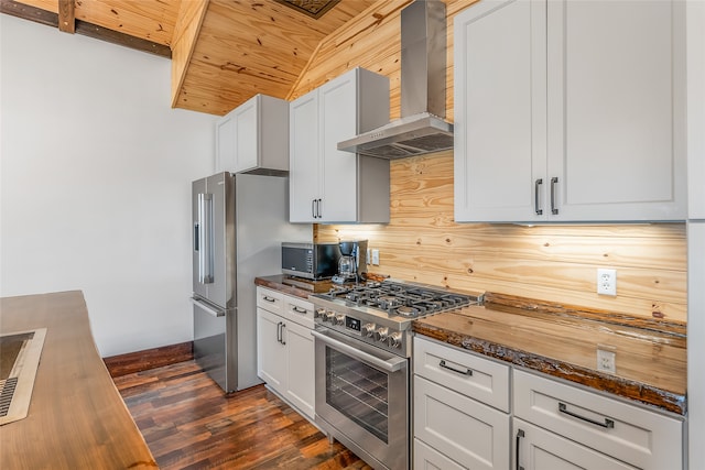 kitchen with appliances with stainless steel finishes, dark hardwood / wood-style floors, dark stone countertops, wooden ceiling, and wall chimney exhaust hood