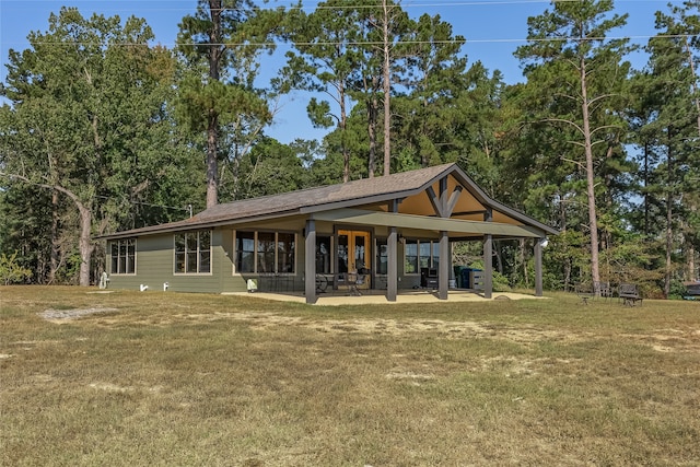 back of property with a yard and a patio