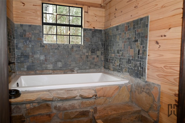 bathroom featuring tile walls and tiled tub