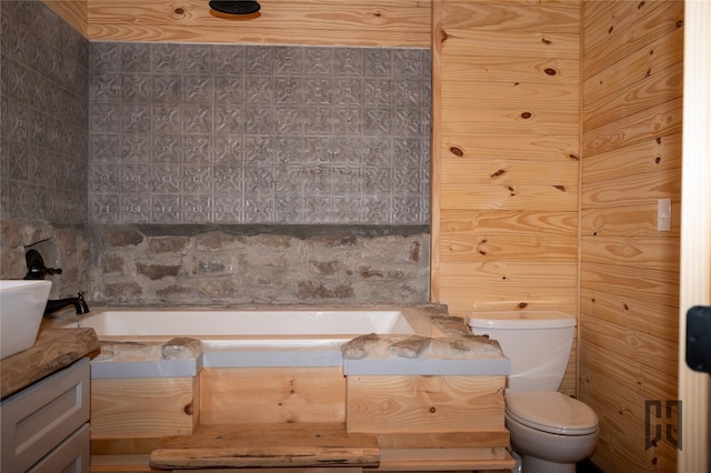 bathroom featuring vanity, a bathing tub, and toilet