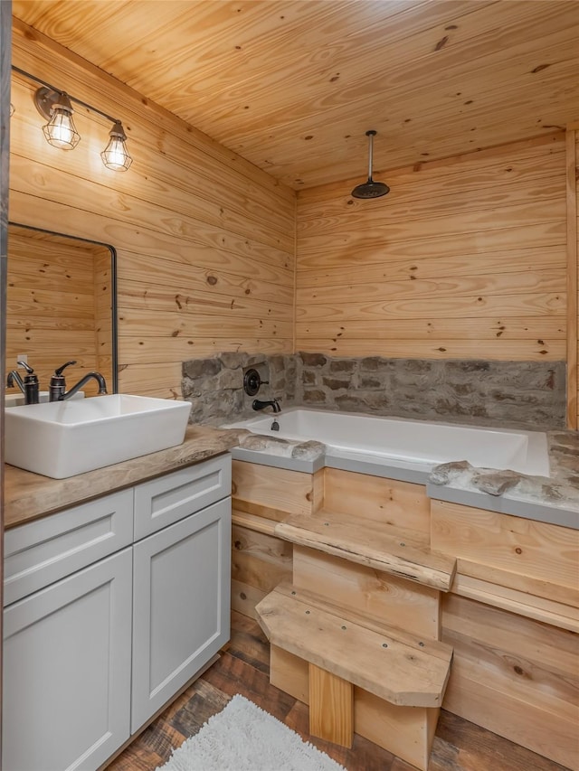 bathroom featuring vanity, a bathing tub, wooden ceiling, and wooden walls