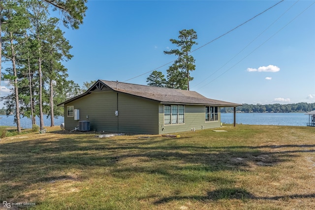 view of side of property with a water view, central AC, and a lawn