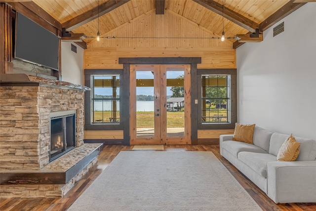 unfurnished living room with a water view, a fireplace, dark hardwood / wood-style floors, and a wealth of natural light