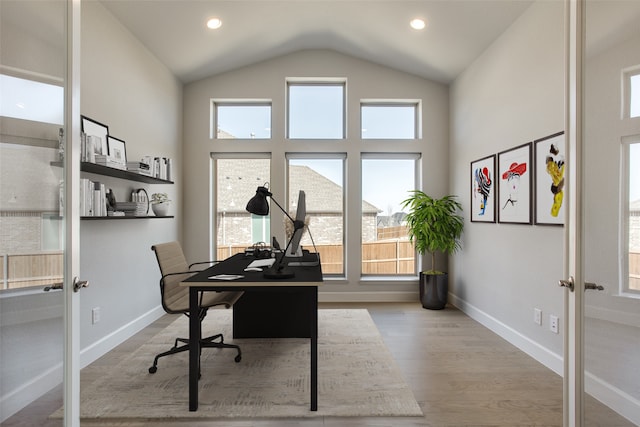 office space featuring french doors, vaulted ceiling, and light wood-type flooring