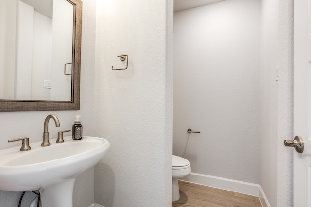 bathroom featuring sink, wood-type flooring, and toilet