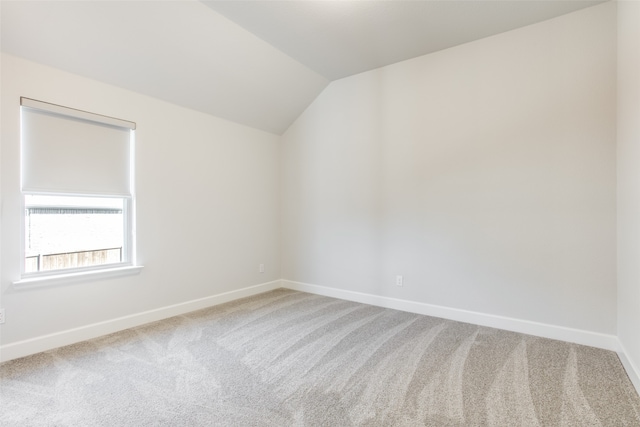 empty room featuring carpet flooring and lofted ceiling