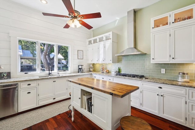 kitchen with wall chimney exhaust hood, white cabinets, dark hardwood / wood-style floors, and stainless steel appliances