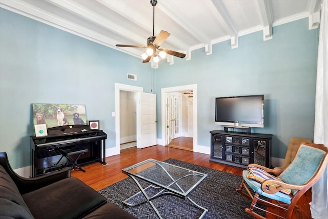 living room featuring beamed ceiling, ornamental molding, hardwood / wood-style flooring, and ceiling fan