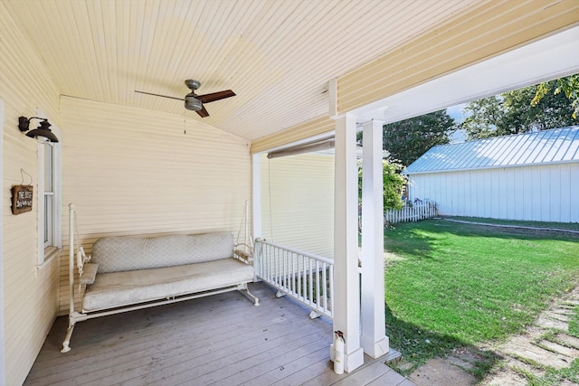 wooden terrace featuring a lawn and ceiling fan