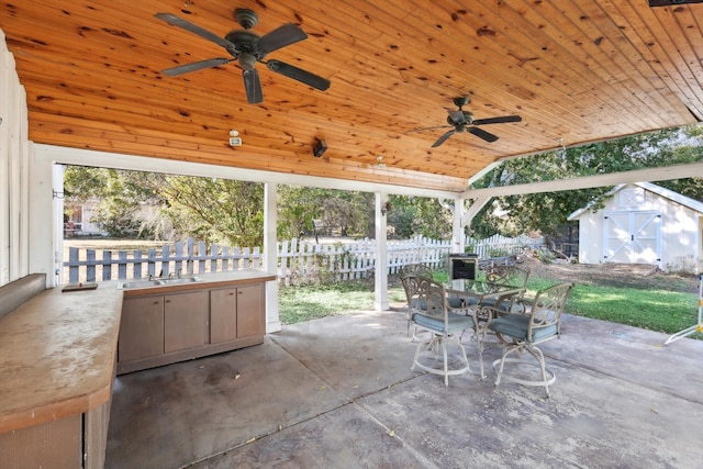 view of patio / terrace with ceiling fan, a storage unit, and sink