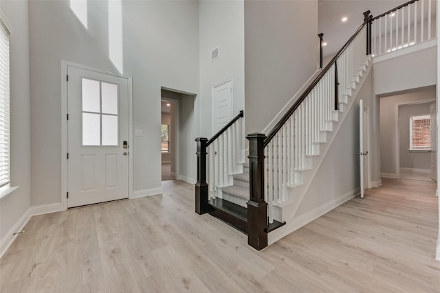 entrance foyer with a high ceiling and light wood-type flooring