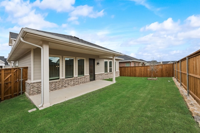 rear view of house with a yard and a patio