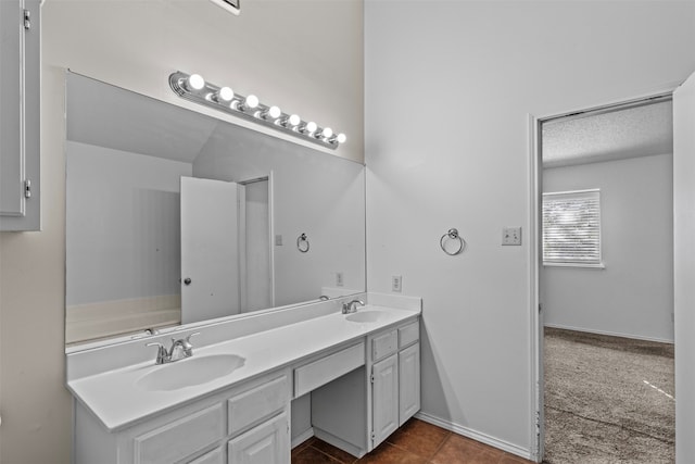 bathroom with vanity, a textured ceiling, and tile patterned flooring