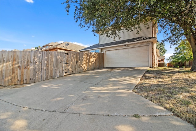 view of front of property featuring central AC and a garage