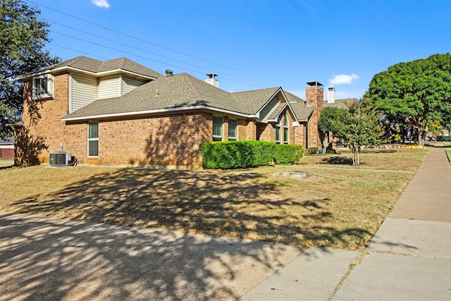 view of side of home featuring central air condition unit and a lawn