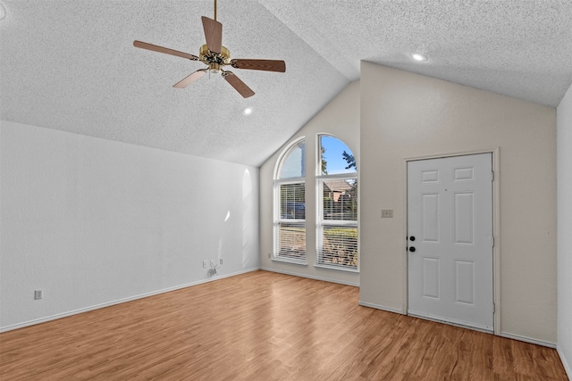 entryway featuring lofted ceiling, a textured ceiling, light hardwood / wood-style floors, and ceiling fan