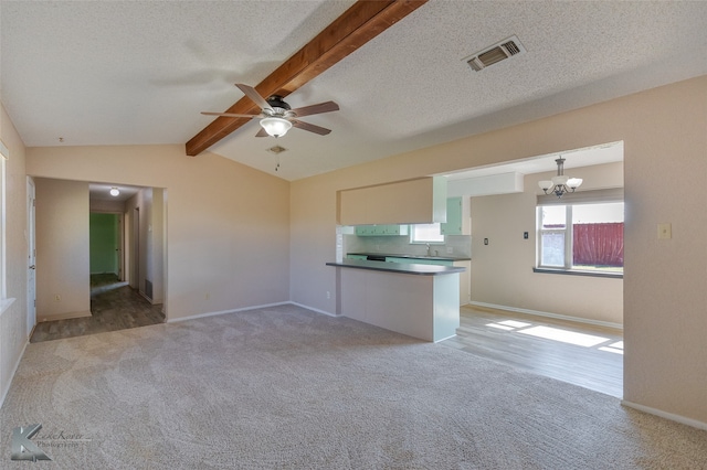 interior space with light carpet, a textured ceiling, vaulted ceiling with beams, and ceiling fan with notable chandelier