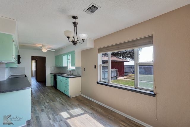 kitchen featuring green cabinetry, sink, and backsplash