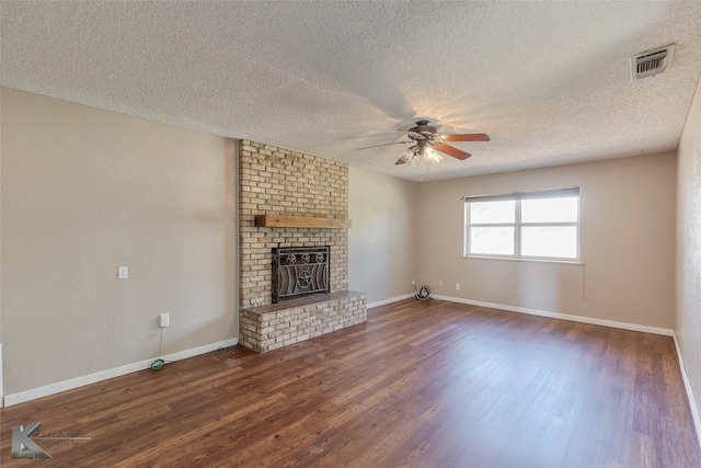 unfurnished living room featuring ceiling fan, a fireplace, a textured ceiling, and dark hardwood / wood-style floors