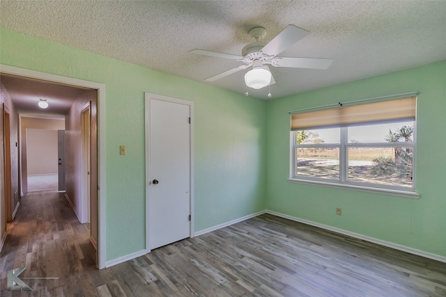 unfurnished bedroom with a closet, a textured ceiling, wood-type flooring, and ceiling fan