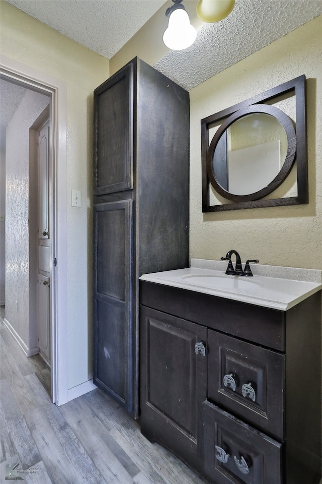 bathroom featuring vanity, a textured ceiling, and hardwood / wood-style floors