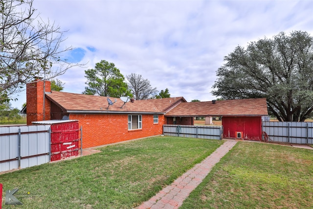 back of property with a storage shed and a yard