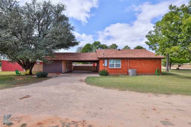 ranch-style house with a front yard, central AC, and a carport