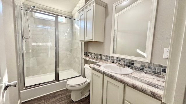 bathroom with hardwood / wood-style floors, vanity, tasteful backsplash, a shower with shower door, and toilet