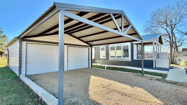 exterior space with a garage, a carport, and an outdoor structure