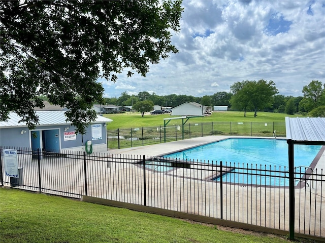 view of swimming pool featuring a patio and a lawn