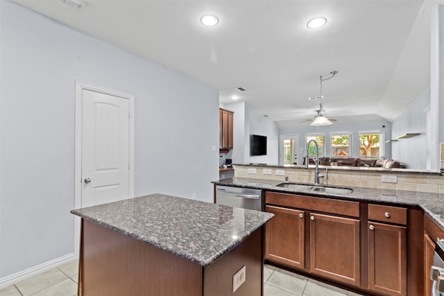 kitchen with decorative backsplash, a center island, dishwasher, and sink