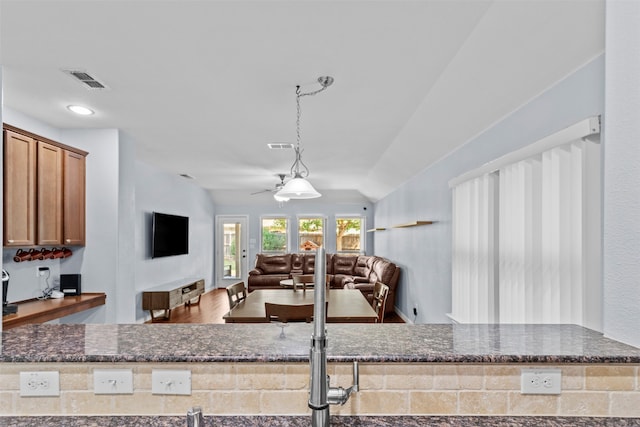 kitchen with hardwood / wood-style flooring, ceiling fan, and vaulted ceiling