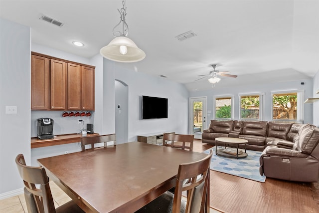 dining room with light hardwood / wood-style flooring, ceiling fan, and vaulted ceiling