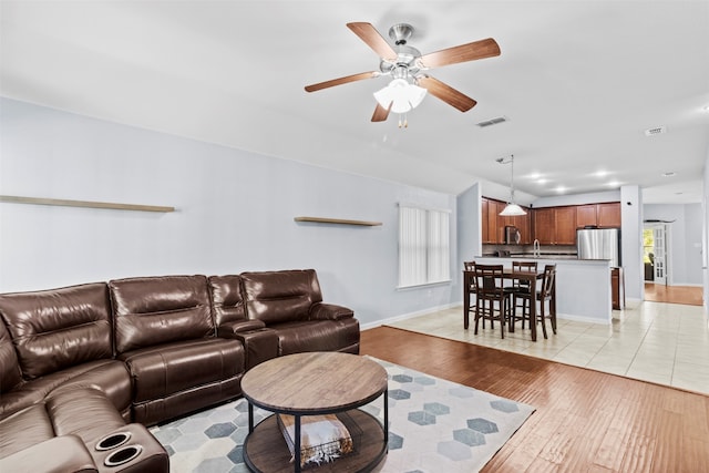 living room featuring light hardwood / wood-style flooring, a healthy amount of sunlight, and ceiling fan