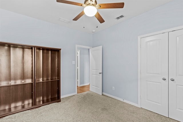 unfurnished bedroom with light carpet, a closet, and ceiling fan